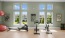 Bright fitness center with rowing machine, stationary bikes, yoga balls, and dumbbell weights