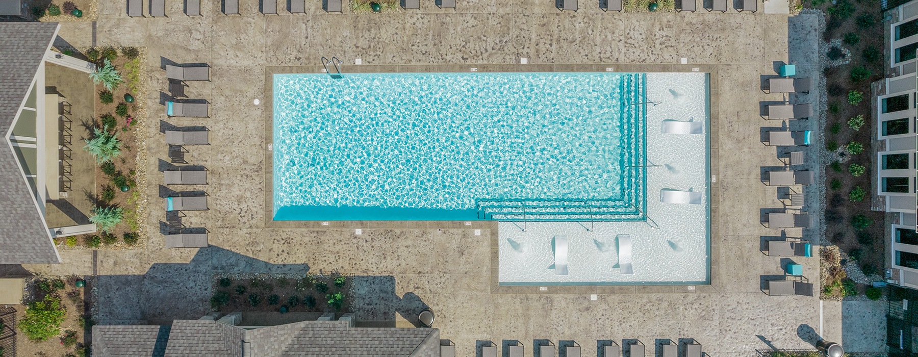 aerial of pool showing nearby reclining seating and nearness to property