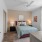 Bedroom with large window, ceiling fan, and modern decor