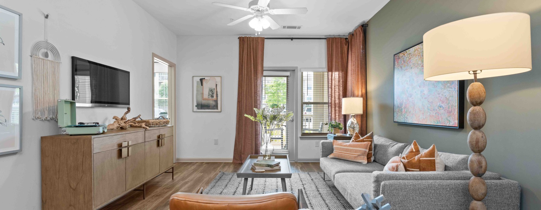 Stylish apartment living room with sofa, accent chair, and natural light
