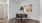 Dining area with round table, chairs, and colorful wall art.