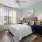 Bedroom with large window, ceiling fan, and modern decor.