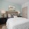 Bedroom with large window, ceiling fan, and modern decor.